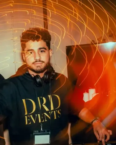 David, DJ de DRD Events, aux platines avec son casque, en sweat DRD Events